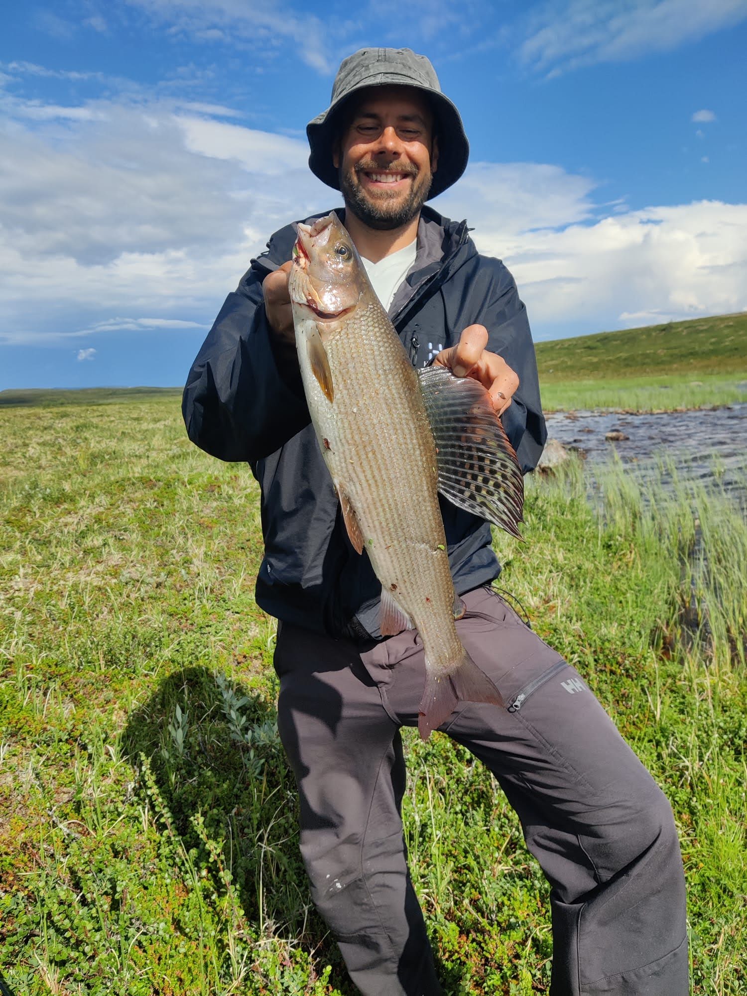 Guide with a trophy grayling in the Finnish tundra
